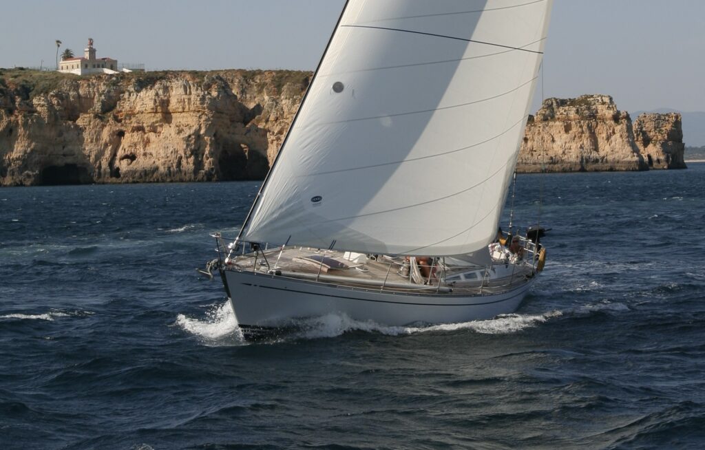 Die Segelyacht Dantés verlässt die Bucht von Lagos vor dem Leuchtfeuer Ponte del Piedade